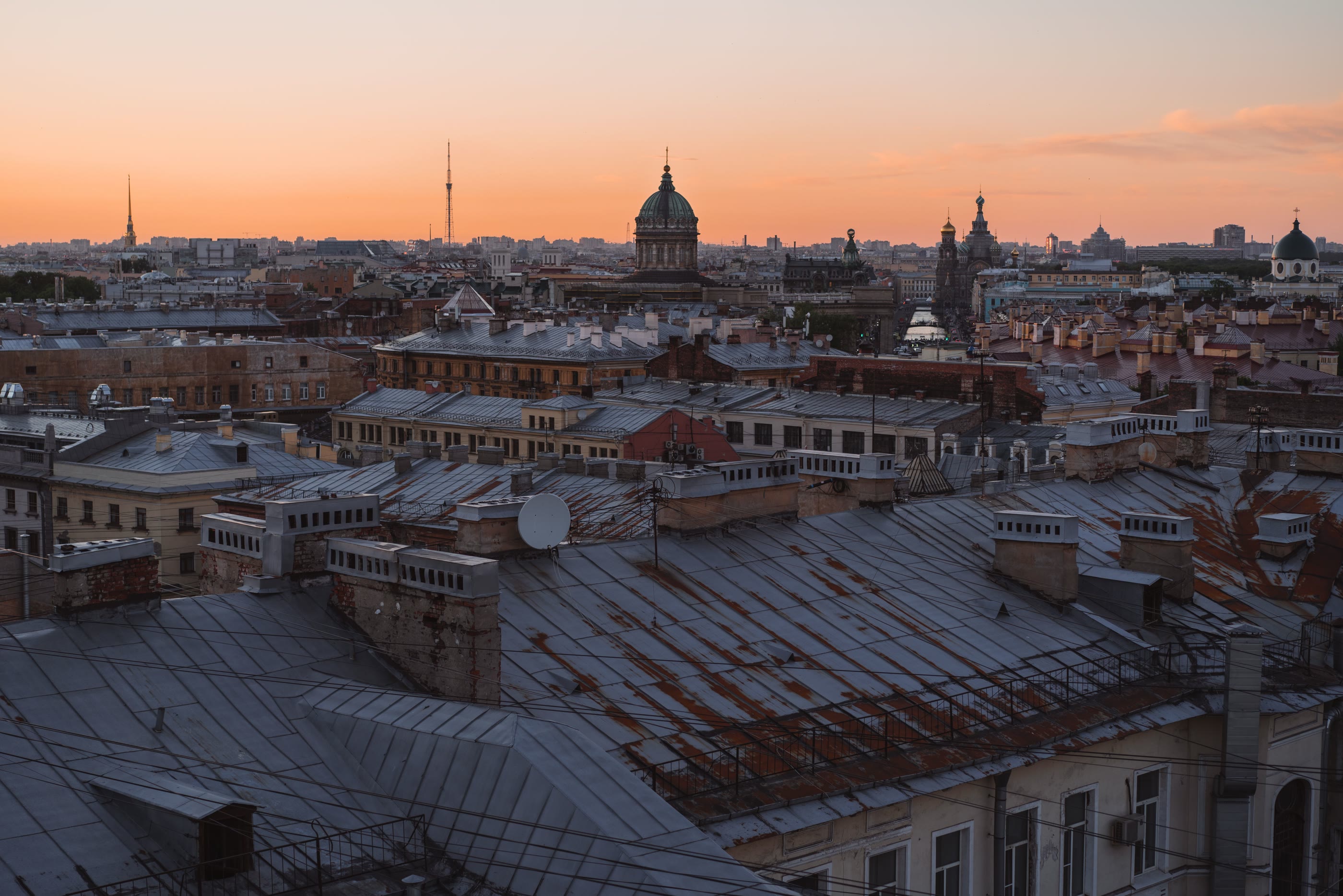 Daken en koepels van een Europese stad bij zonsondergang.