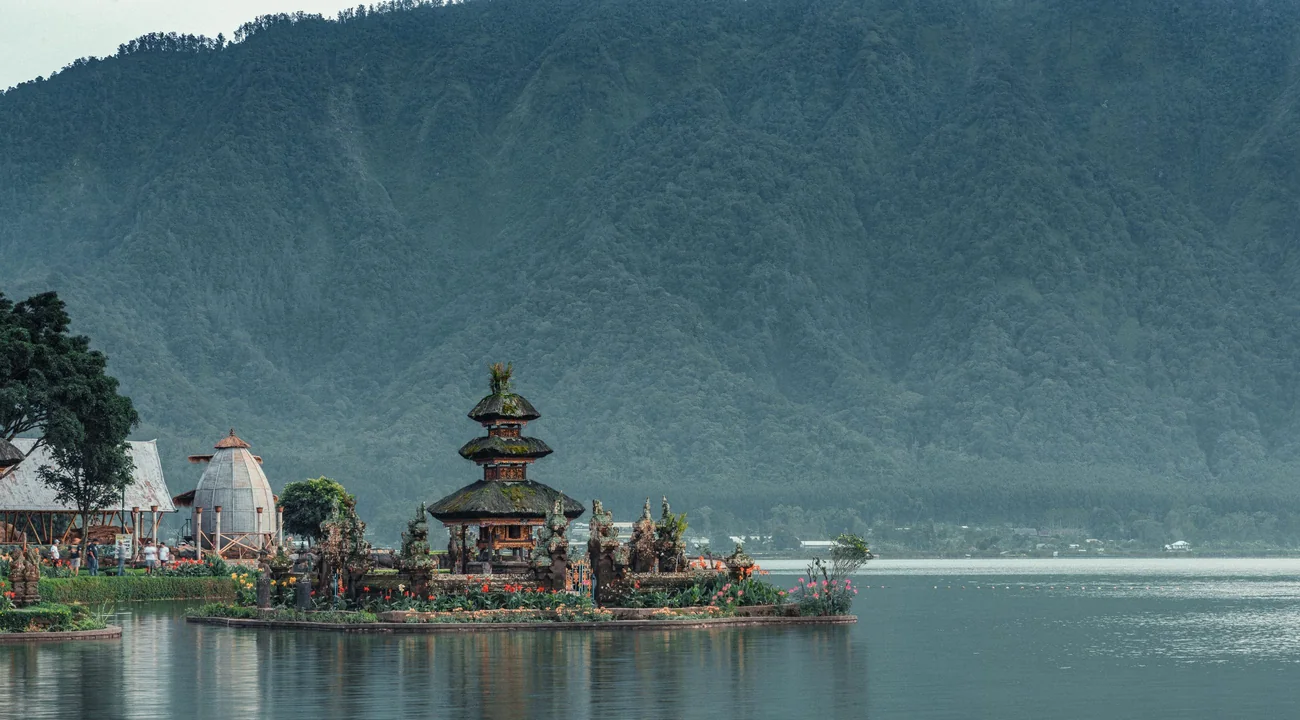 Balinese tempel aan een meer, omringd door beboste bergen