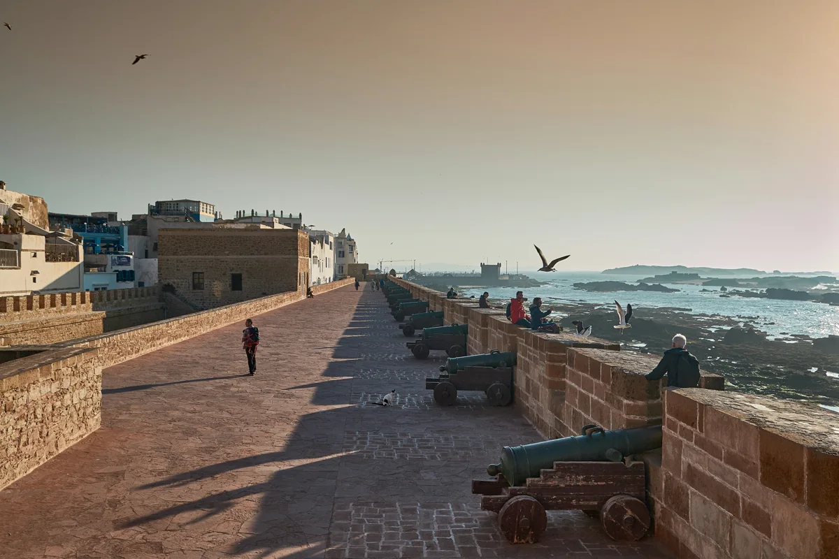 Vestingmuur met oude kanonnen boven de kust van Essaouira, met de medina op de achtergrond