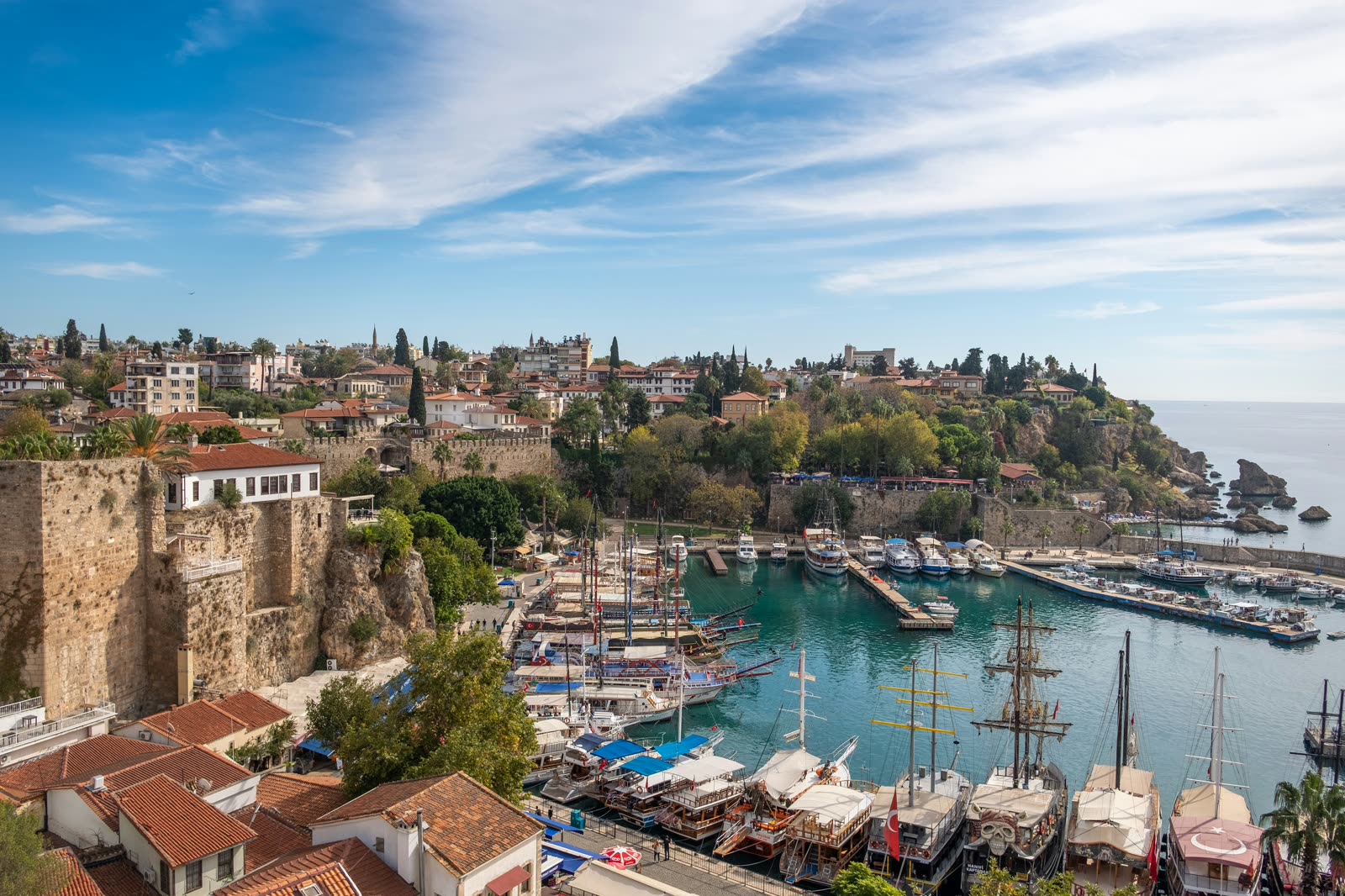 Jachthaven van Antalya met boten en de oude stadsmuur op de achtergrond
