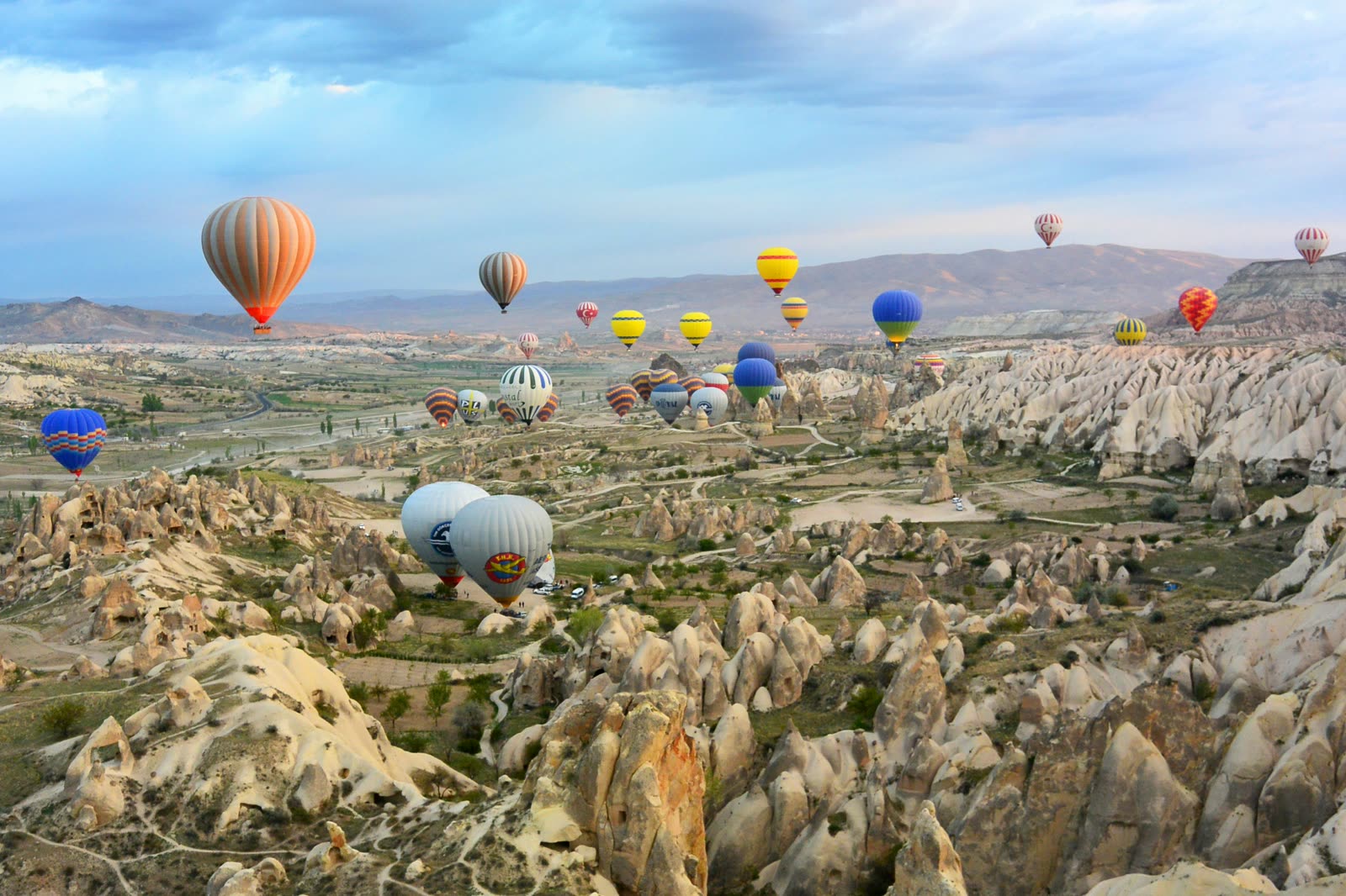 Luchtballonnen boven de rotsformaties van Cappadocië bij zonsopgang