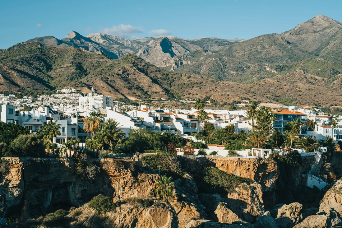 Wit dorp tegen de bergen van Andalusië, met kliffen aan de kust.