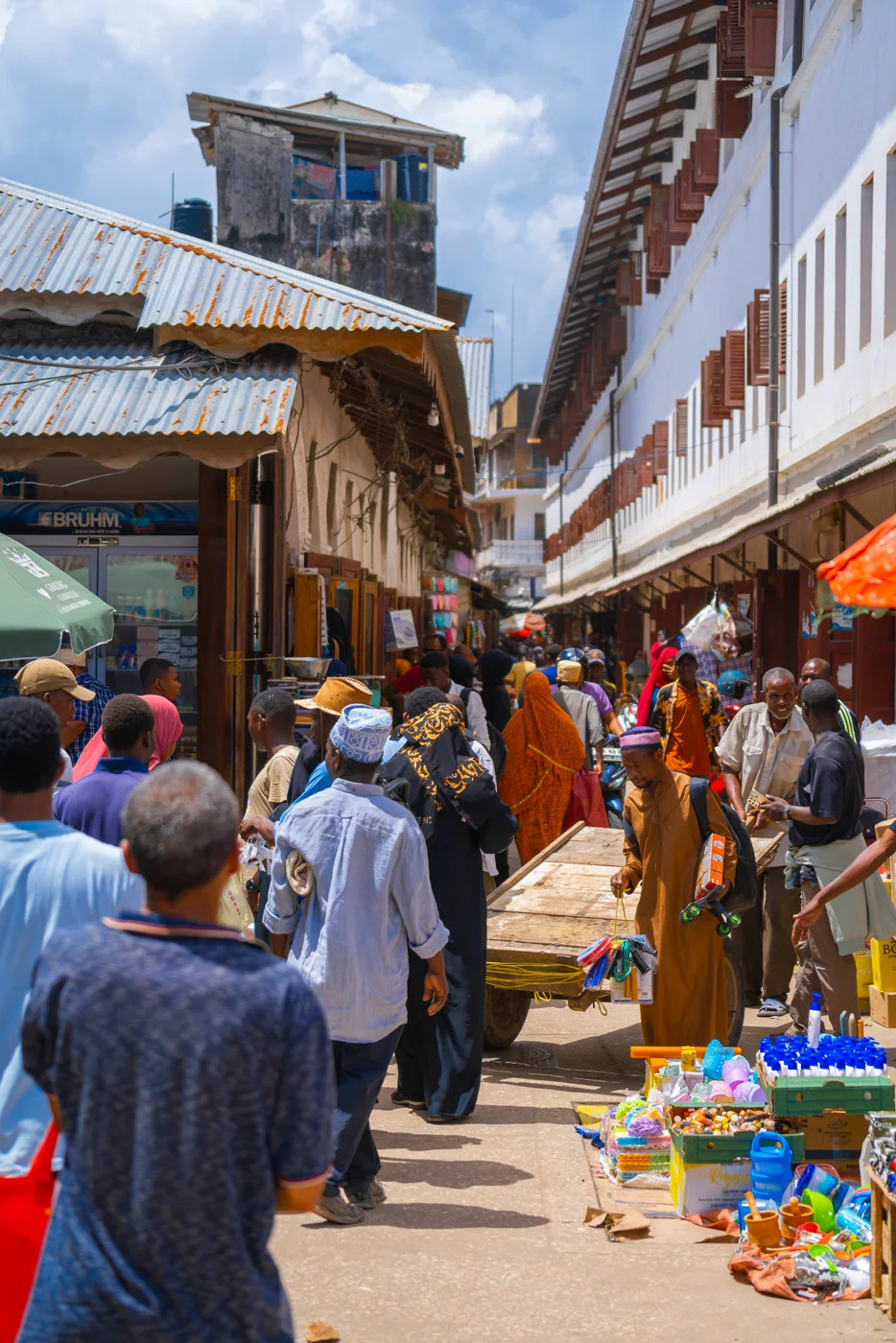 Drukke marktstraat in Zanzibar met kramen en voorbijgangers tussen traditionele gebouwen